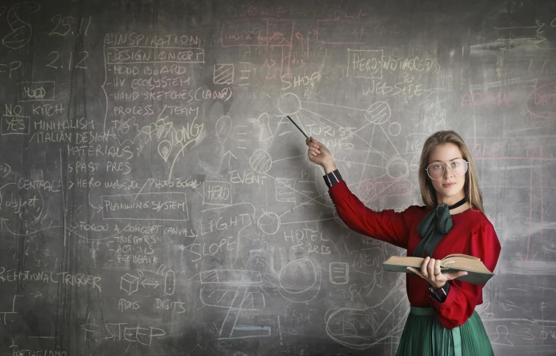 a woman standing in front of a blackboard writing on it, inspired by Harriet Powers, trending on pexels, analytical art, nerdy music teacher with phd, marvelous designer substance, inspired in balthus, press shot