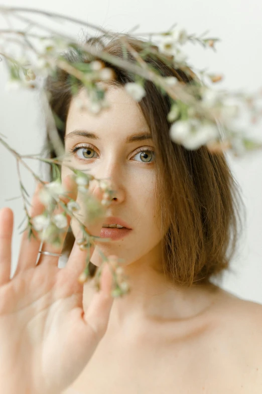 a woman with a flower crown on her head, inspired by Elsa Bleda, pexels contest winner, aestheticism, branches sprouting from her head, soft oval face, indoor picture, manuka