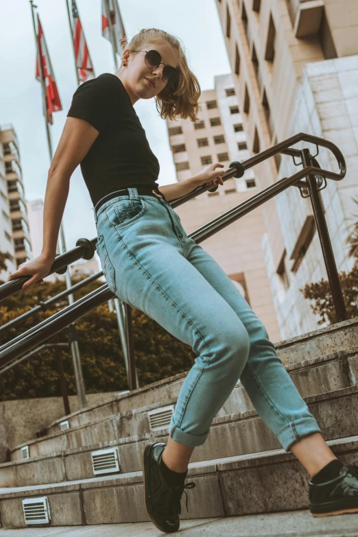 a woman riding a skateboard down a flight of stairs, trending on pexels, happening, blue pants, at a city street, pastels, ( ( ( wearing jeans ) ) )