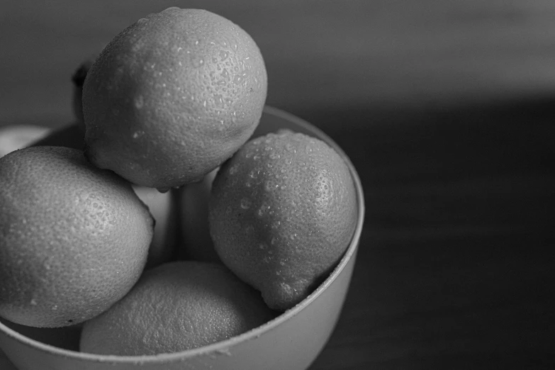 a black and white photo of lemons in a bowl, puffballs, ambient oclusion, sigma 1.6, foam