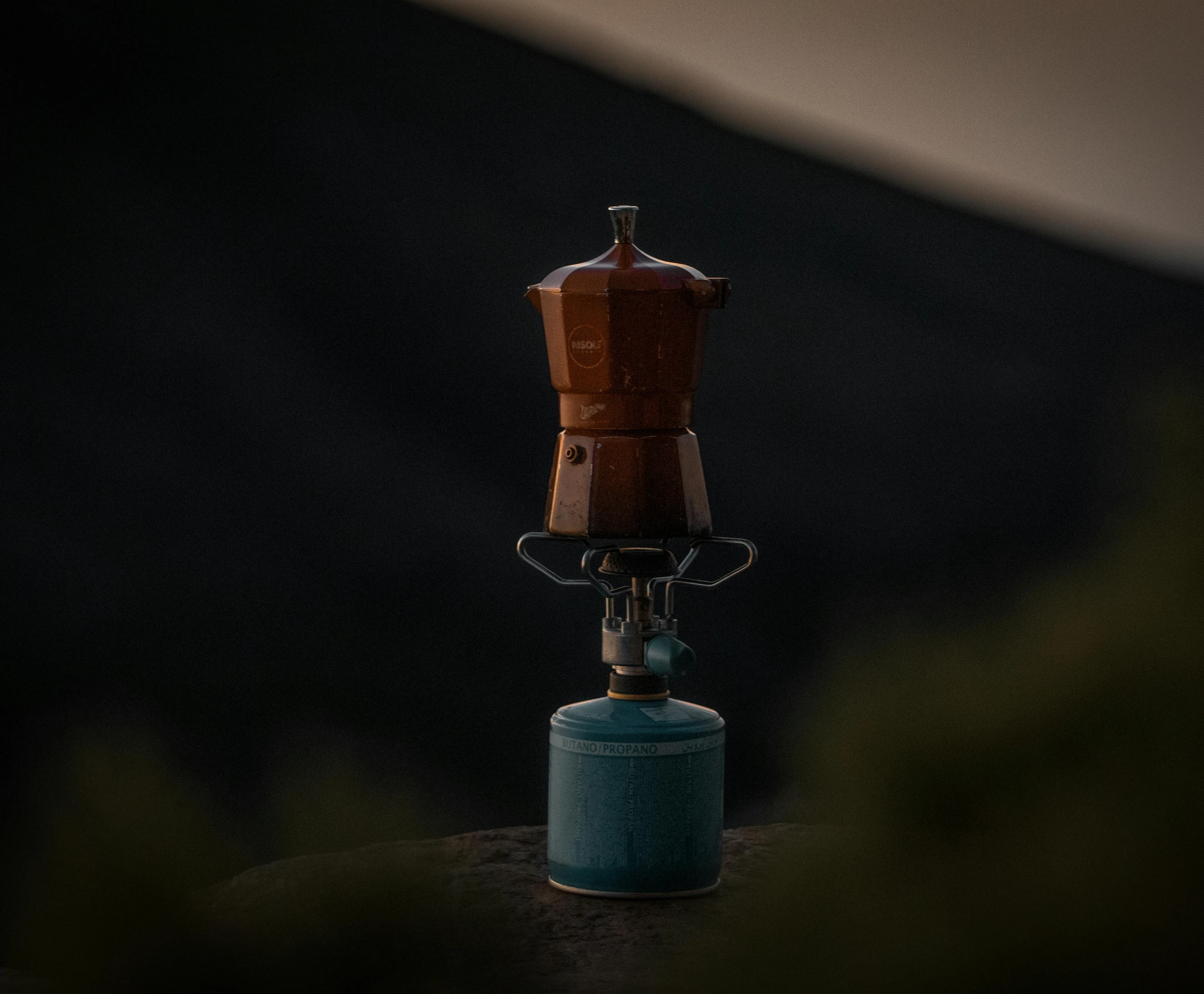 a stove that is sitting on top of a rock, a still life, by Filip Hodas, unsplash contest winner, ancient coffee machine, camping, miniature product photo, blue