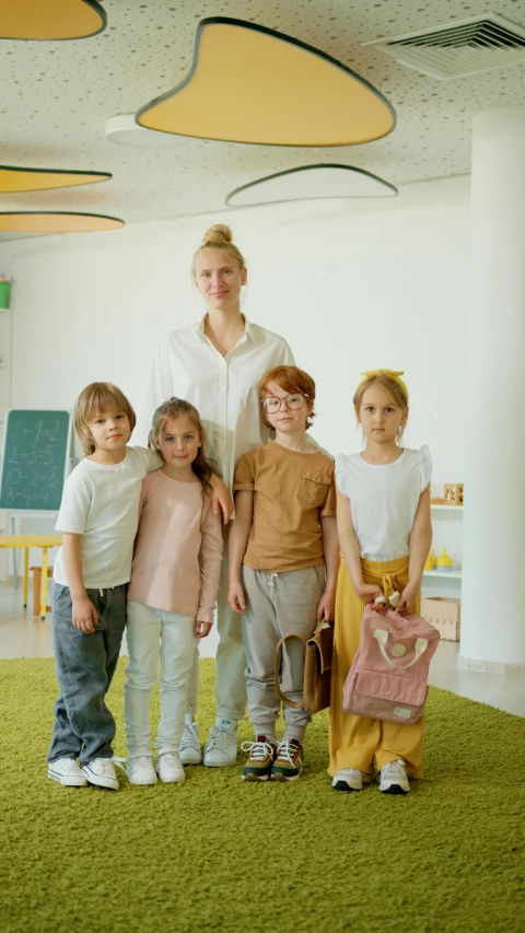 a woman standing next to a group of children, inspired by Elsa Beskow, pexels, paris school, wearing a baggy, inside elementary school, portrait shot 8 k, a blond