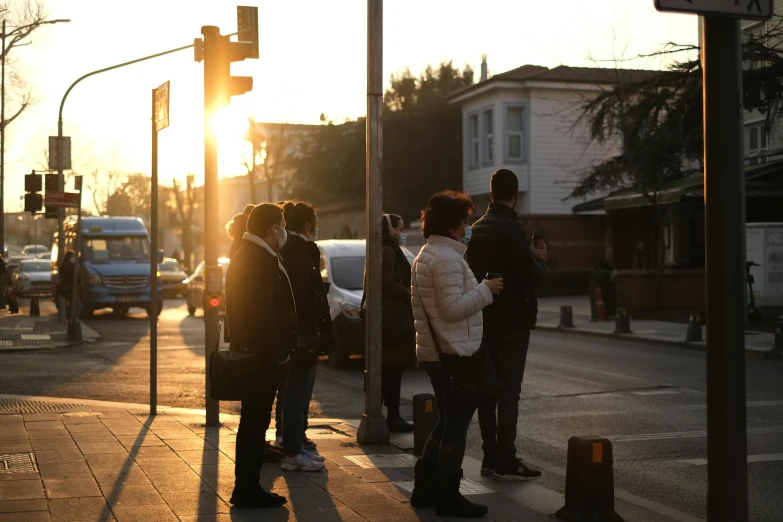 a group of people standing on the side of a street, by Jang Seung-eop, flickr, golden hour in beijing, bus stop, turkey, ap news photo