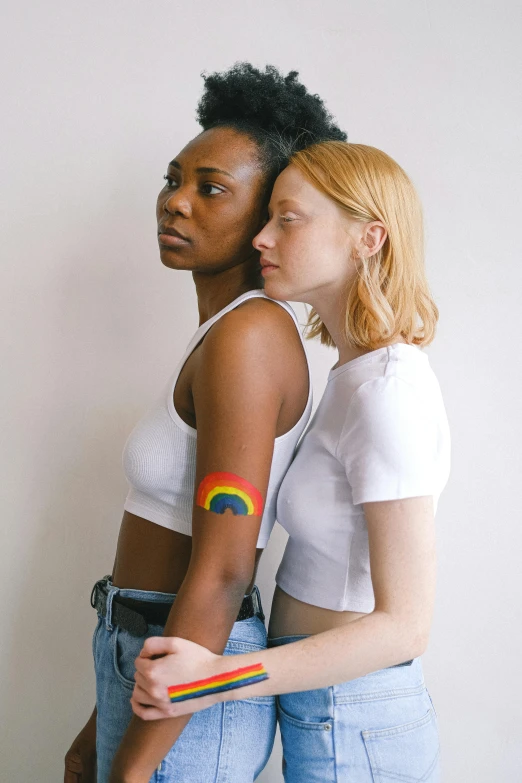 a couple of women standing next to each other, by Jessie Alexandra Dick, trending on pexels, renaissance, rainbow accents, temporary tattoo, sadie sink, diverse