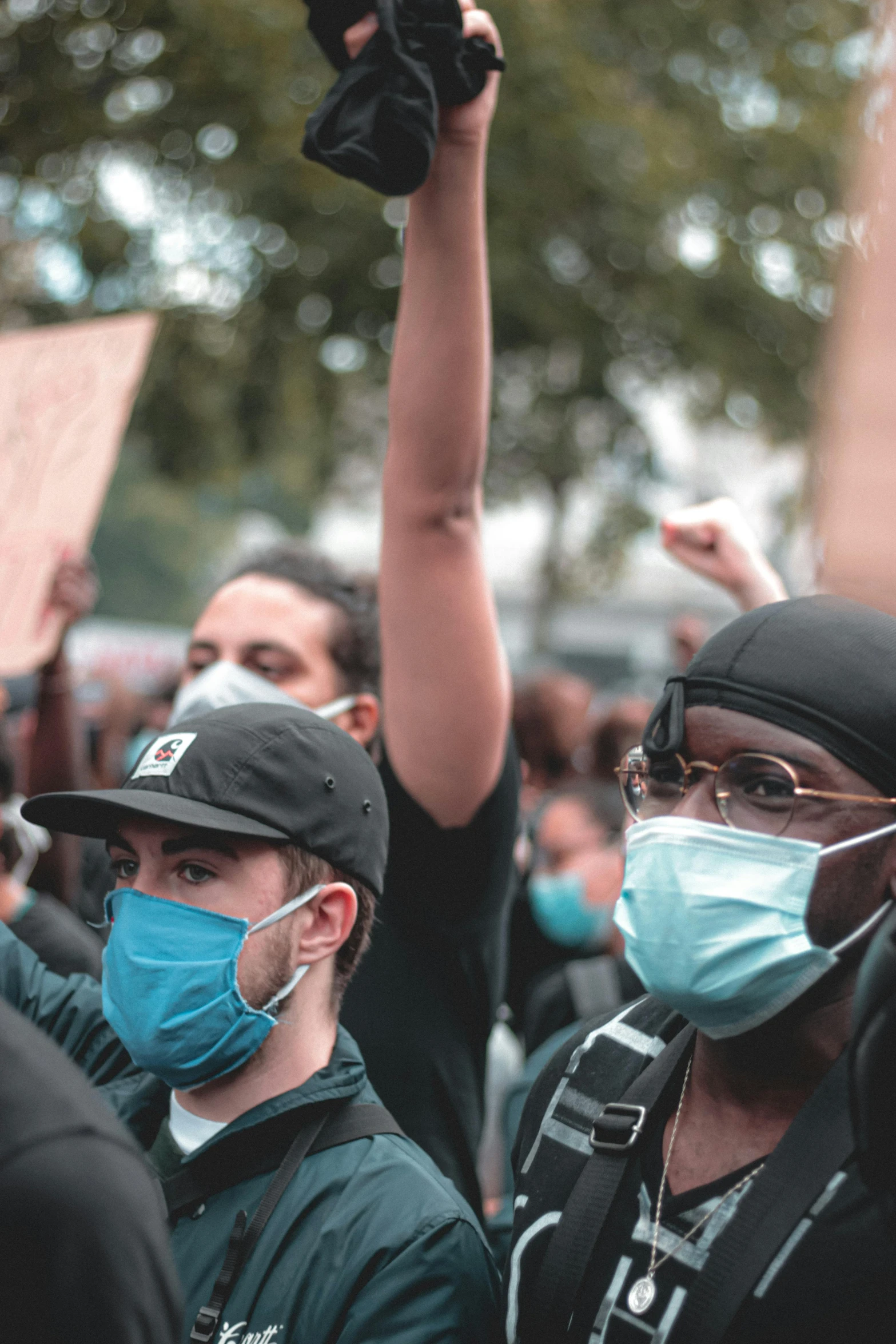 a group of people wearing masks and holding up signs, by Matija Jama, pexels, renaissance, black and teal paper, tear gas, medium shot of two characters, profile pic