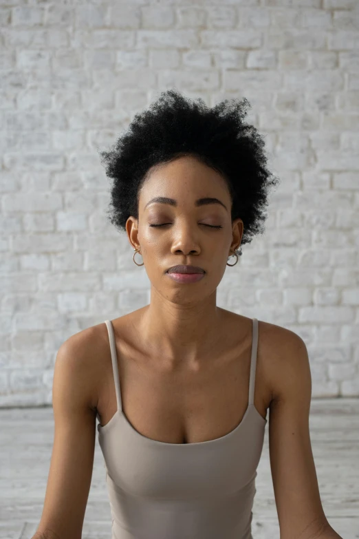 a woman sitting in a yoga position with her eyes closed, by Lily Delissa Joseph, natural complexion, pictured from the shoulders up, pouty face, loosely cropped