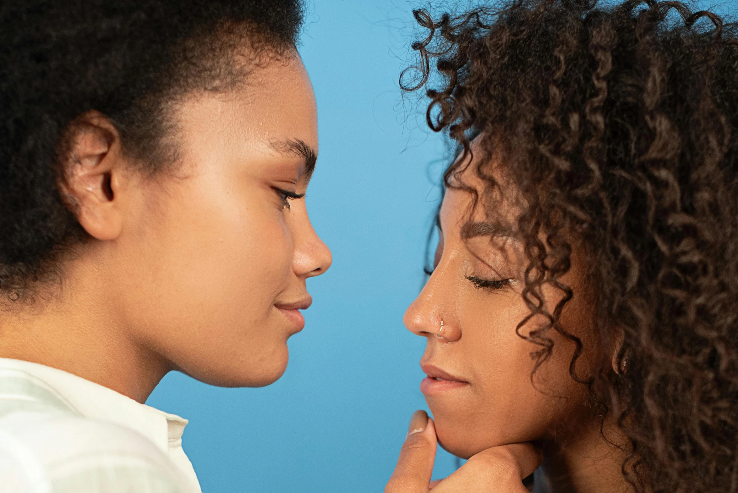 a couple of young women standing next to each other, trending on pexels, romanticism, large pores, mixed race, facing each other, up close