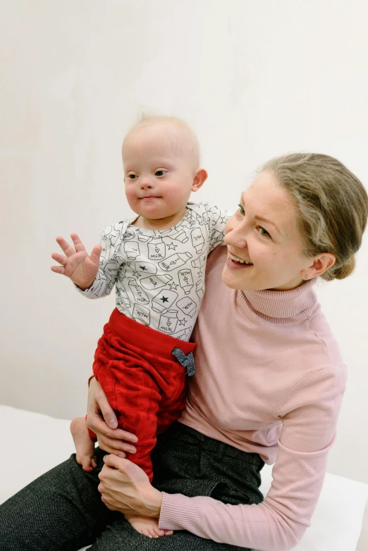 a woman holding a baby in her arms, by Ellen Gallagher, greta thunberg smiling, studio photo, marfan syndrome, square