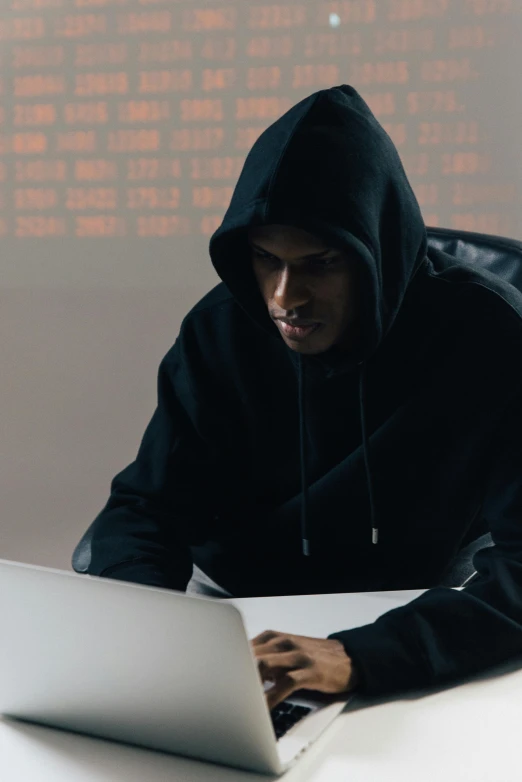 a man in a hoodie working on a laptop, a computer rendering, pexels, wearing black clothes and cape, crimes, ( ( theatrical ) ), gif