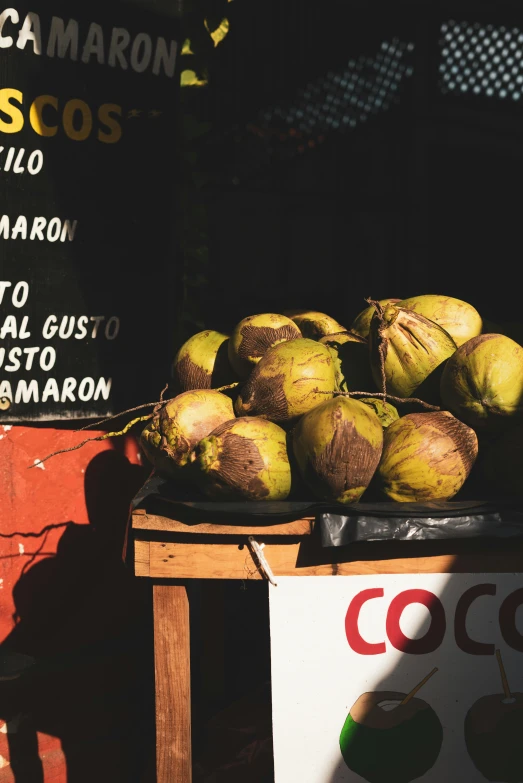 a pile of coconuts sitting on top of a table, by Matt Cavotta, pexels contest winner, stood outside a corner shop, thumbnail, background image, spanish