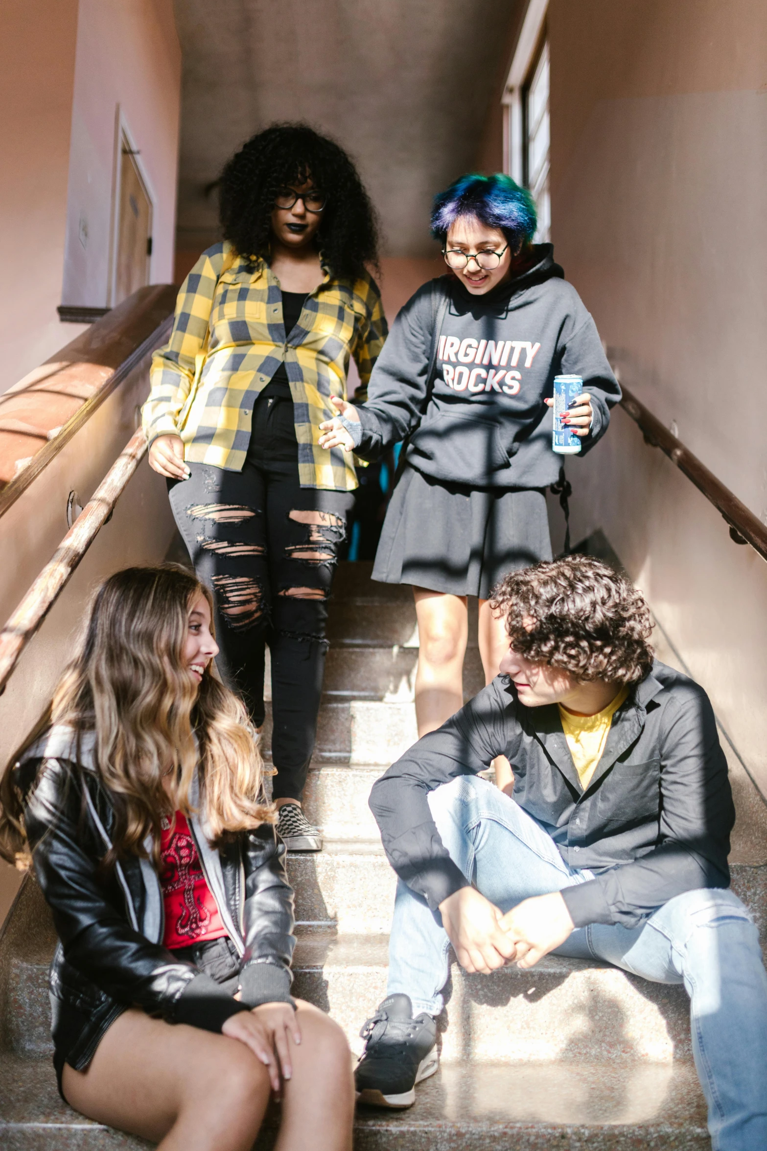 a group of young people sitting on a set of stairs, by Bernie D’Andrea, trending on pexels, renaissance, tall female emo art student, bay area, in school hallway, wearing ragged clothing