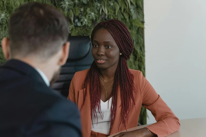 a man and a woman sitting at a table, dark skin tone, selling insurance, girl in suit, lachlan bailey