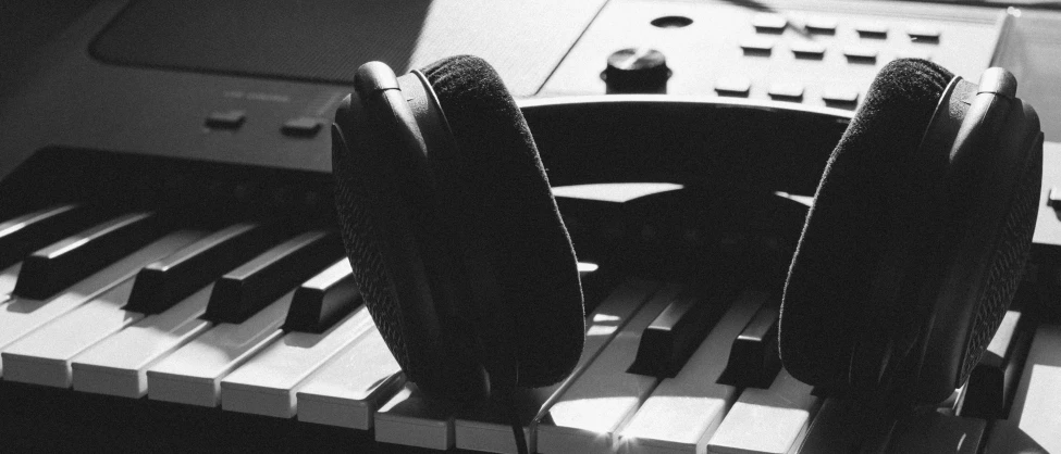 a pair of headphones sitting on top of a keyboard, by Niko Henrichon, precisionism, playing piano, black and white), studio microphone, uploaded