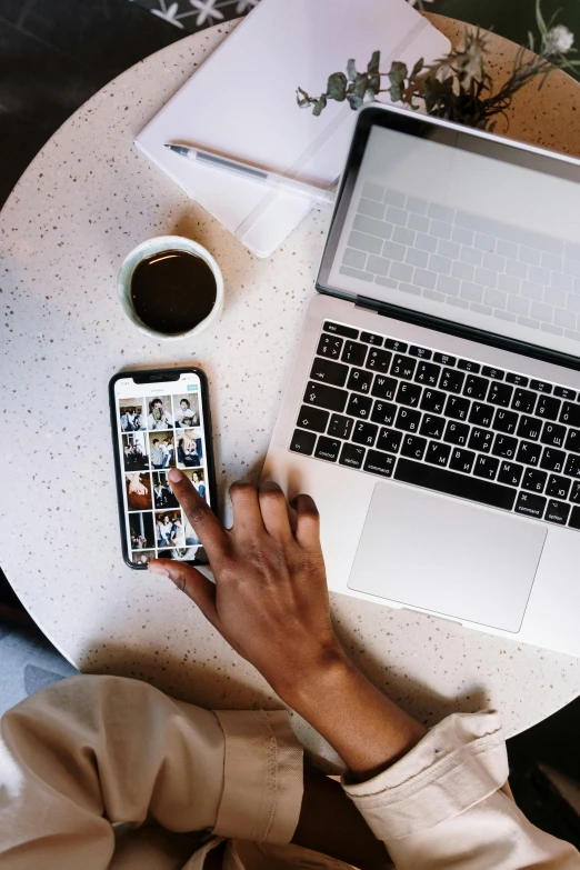 a person sitting at a table with a laptop and a cell phone, a picture, trending on pexels, flatlay, corporate phone app icon, dark-skinned, long