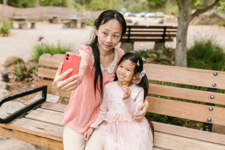 a woman and a little girl sitting on a bench, a picture, pexels contest winner, 8k selfie photograph, an asian woman, on a canva, full device
