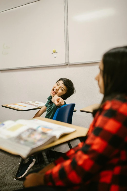 a group of people sitting at desks in a classroom, a picture, pexels contest winner, vancouver school, medium shot of two characters, smiling at each other, kid, nanae kawahara