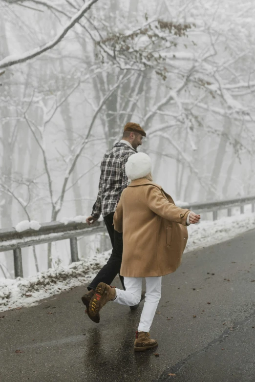 a couple of people that are walking in the snow, by Lucia Peka, pexels contest winner, be running up that hill, a blond, retro vibe, gif