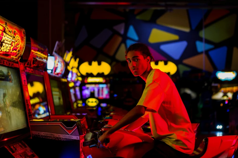 a young man is playing a video game, by Sam Black, unsplash, pop art, film still of batman, inside a casino, lachlan bailey, arcade