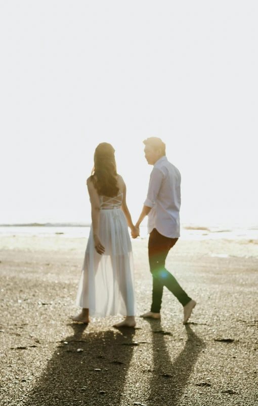 a man and woman walking on a beach holding hands, a picture, unsplash, renaissance, cinematic outfit photo