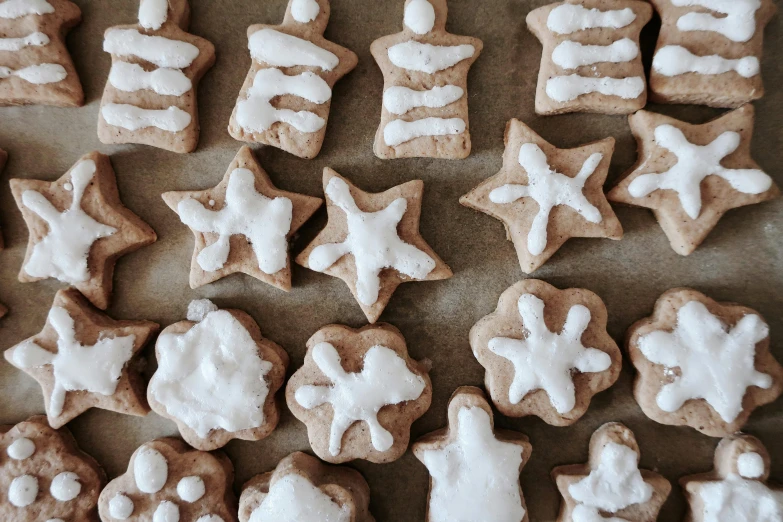 a table topped with lots of cookies covered in icing, by Emma Andijewska, trending on pexels, flour dust spray, 3 winter deities, tan, simple shape