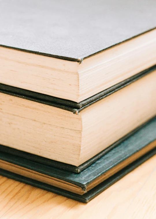 a stack of books sitting on top of a wooden table, thumbnail, detailed product image