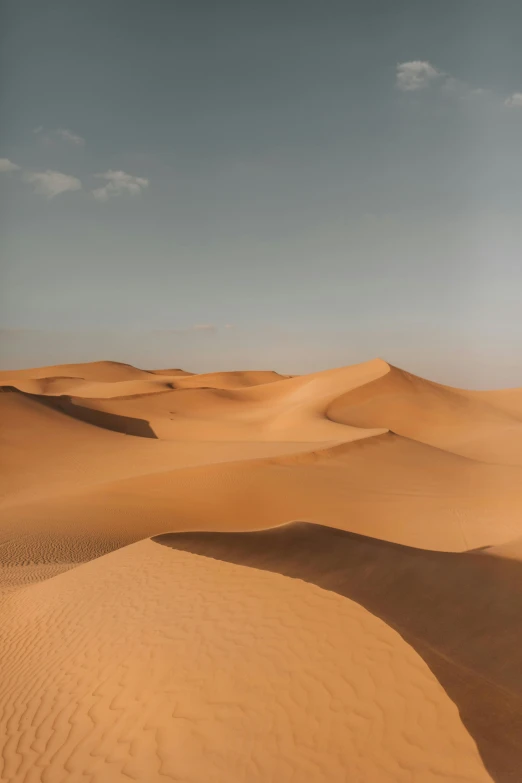 sand dunes in the desert under a blue sky, by Daniel Seghers, trending on unsplash, les nabis, low quality photo, arabia, golden hues, sand - colored walls