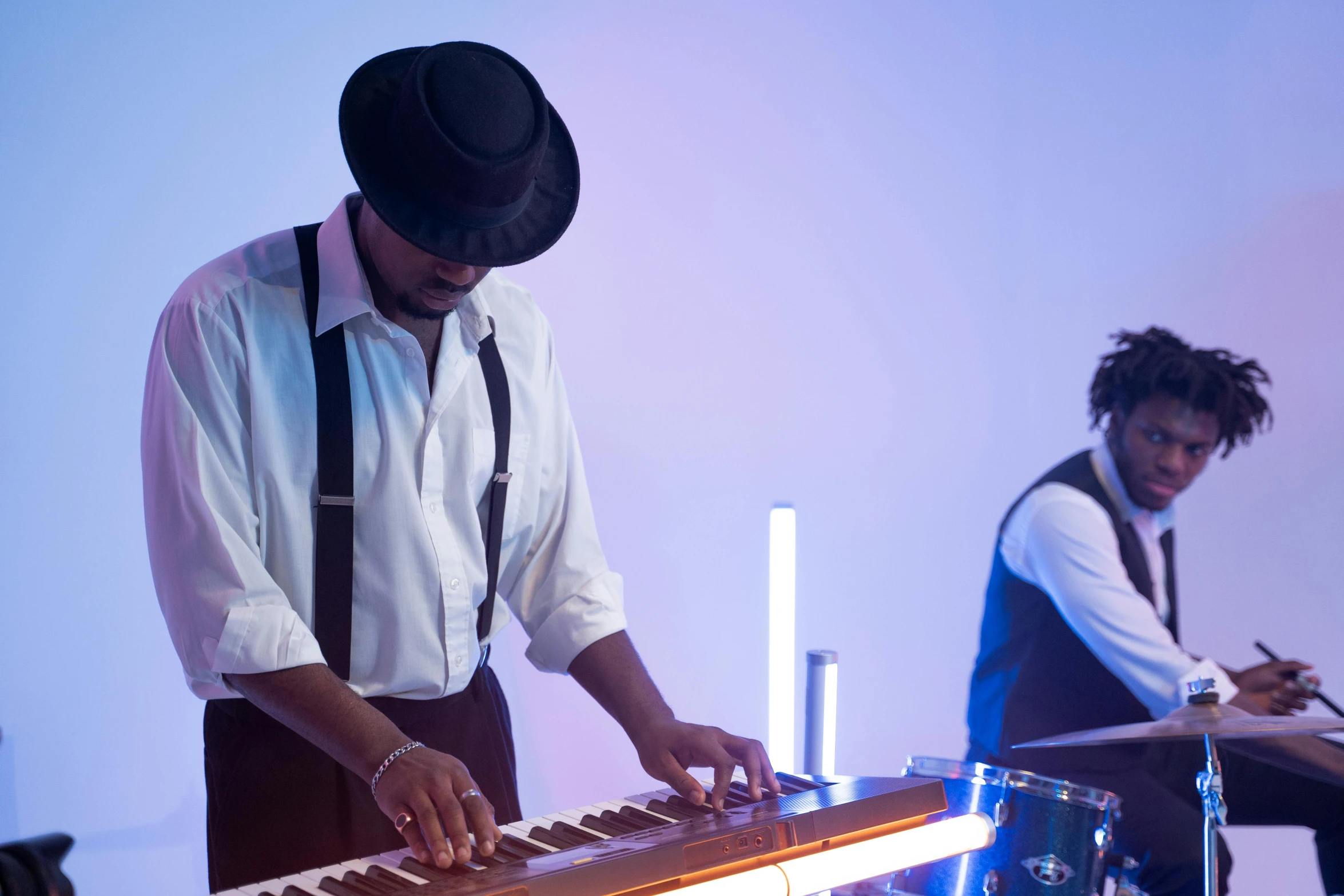 a man that is standing in front of a keyboard, musicians playing instruments, lit from the side, wedding, afro tech