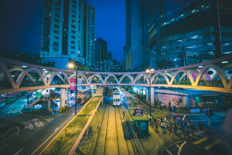 a train traveling through a city at night, by Patrick Ching, pexels contest winner, kowloon walled city style, avenida paulista, cinematic blue and gold, instagram post