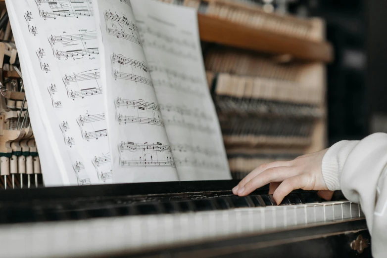 a close up of a person playing a piano, an album cover, pexels contest winner, school class, sheet music, profile image, no watermarks