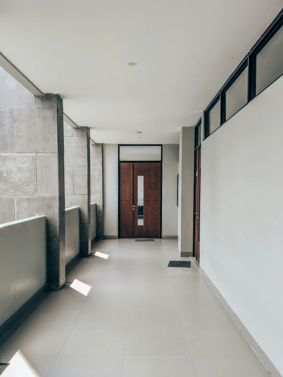 a long hallway leading to a door in a building, a photo, unsplash, light and space, balcony door, medical complex, grey, background image