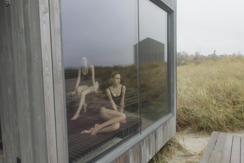 a couple of women sitting in front of a window, a picture, by Maria van Oosterwijk, unsplash, hyperrealism, on the sand, sauna, slight overcast weather, a still of an ethereal