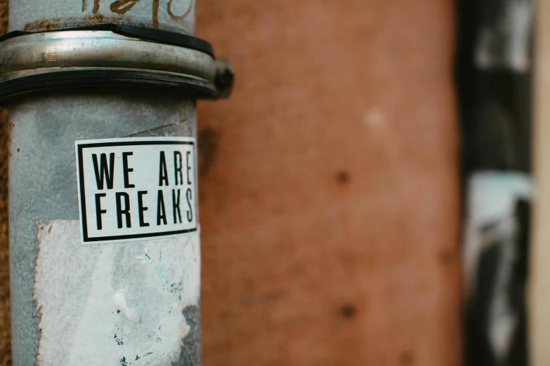 a close up of a pole with a sticker on it, trending on pexels, graffiti, invoke fear and dread, lesbians, water fountain, letterbox