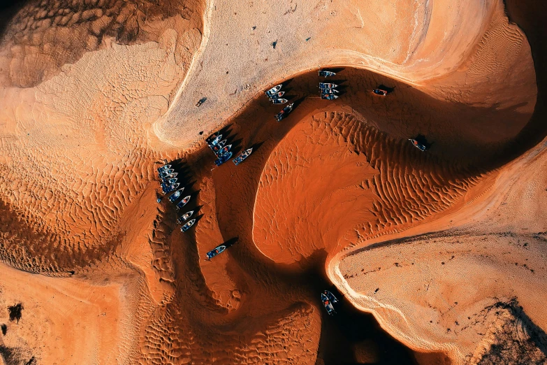 a group of people standing on top of a desert, by Lee Loughridge, pexels contest winner, hurufiyya, close-up from above, dune (2021), an extremely large cave, satellite imagery