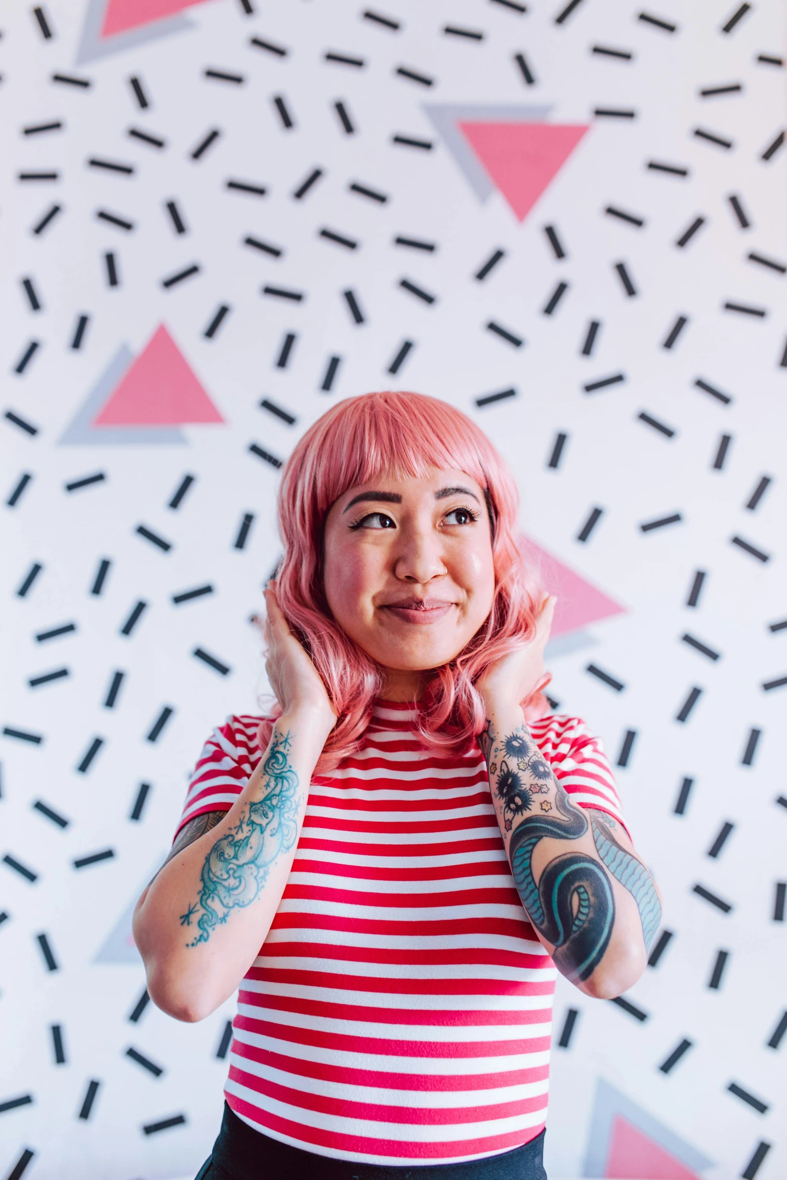 a woman with pink hair standing in front of a wall, a photo, inspired by Kanō Tan'yū, trending on pexels, sarah andersen, in front of white back drop, alex yanes, patterned