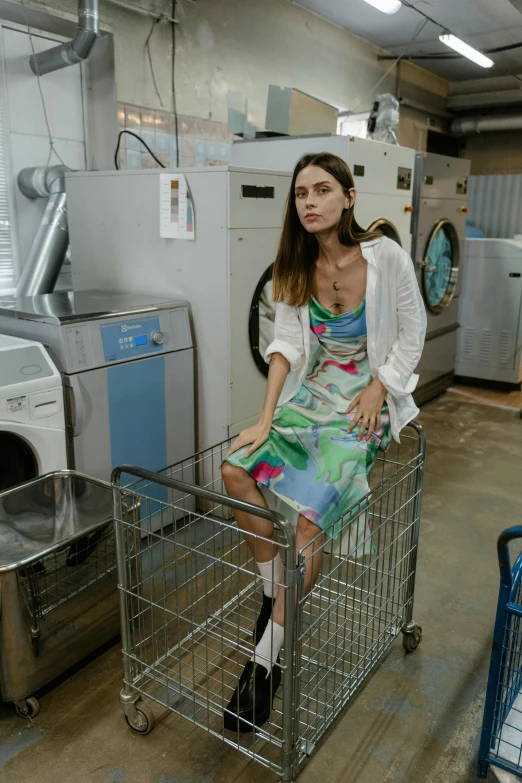 a woman sitting in a shopping cart in a laundry room, inspired by Elsa Bleda, pexels contest winner, process art, low cut dress, miranda kerr, multi - coloured, handsome girl