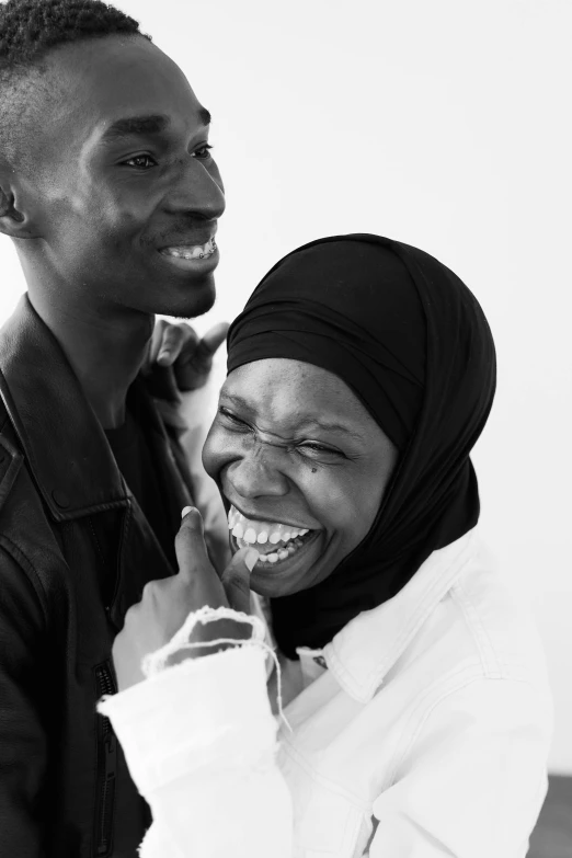 a black and white photo of a man and a woman, by Charly Amani, pexels contest winner, hurufiyya, mutahar laughing, adut akech, face is wrapped in a black scarf, courtesy of moma