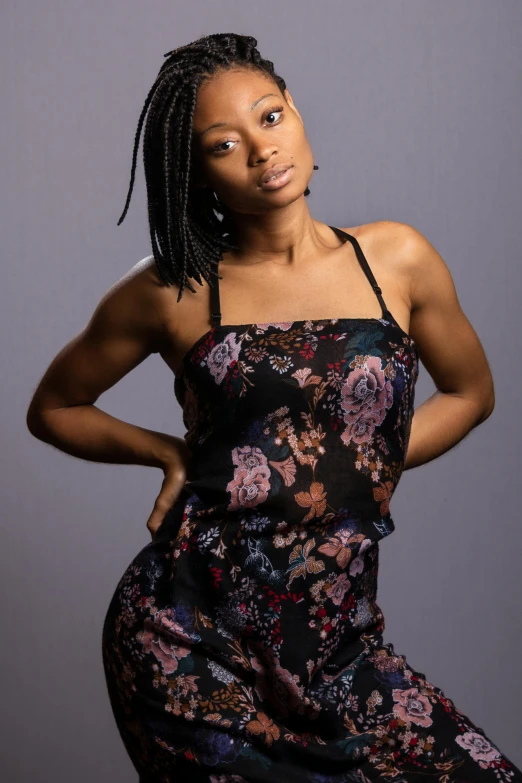 a woman in a floral dress posing for a picture, a portrait, by Leonard Daniels, trending on pexels, tight black tank top and shorts, willow smith young, studio lit, dreadlock black hair