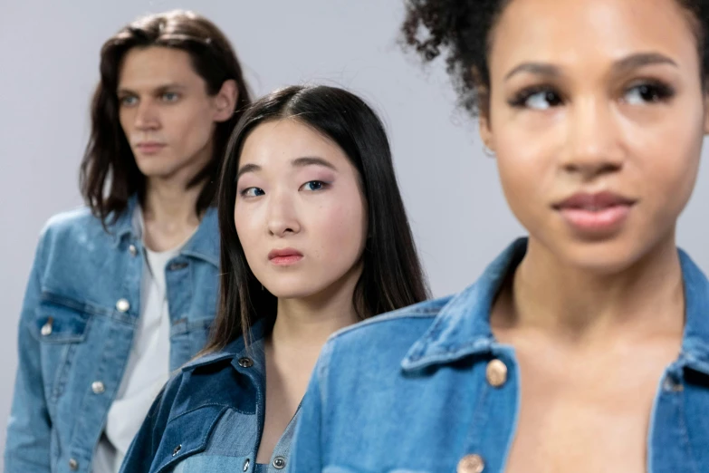 a group of young women standing next to each other, trending on pexels, hyperrealism, stern expression, wearing denim, mixed-race woman, people enjoying the show