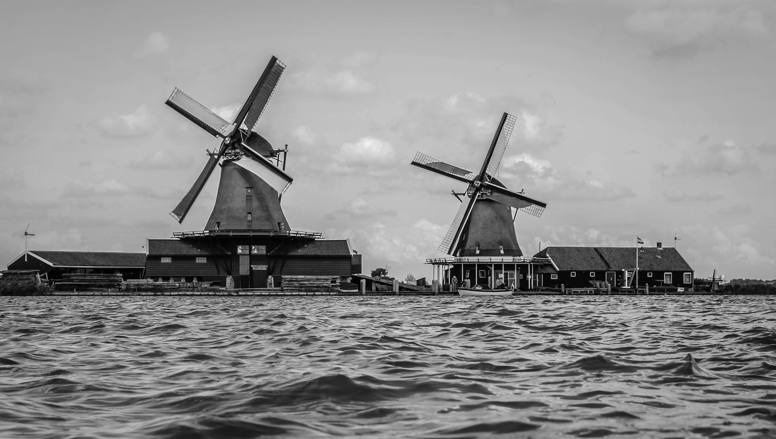 a couple of windmills sitting on top of a body of water, a black and white photo, by Michiel van Musscher, pexels contest winner, portrait of a big, server, wooden buildings, ornately detailed