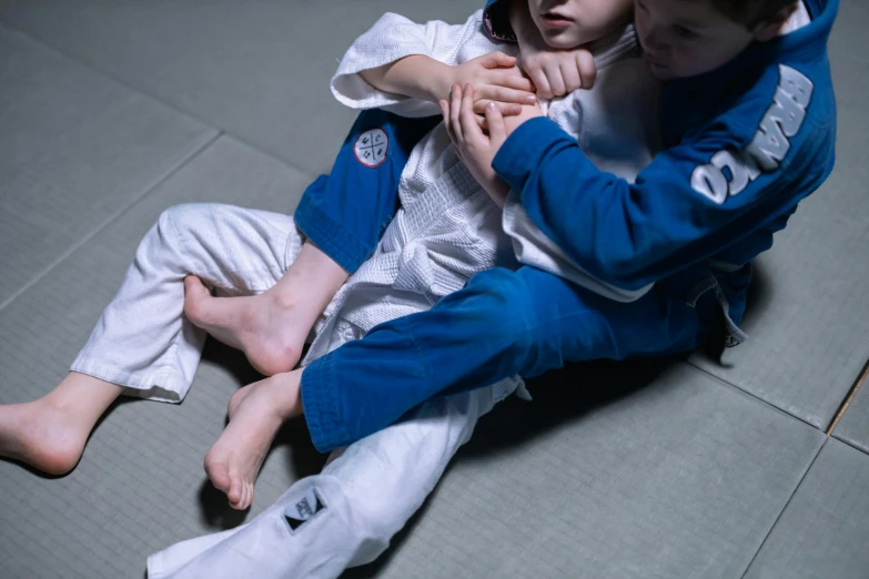 a couple of kids sitting on top of a floor, kimura, up close, gripping, blue print