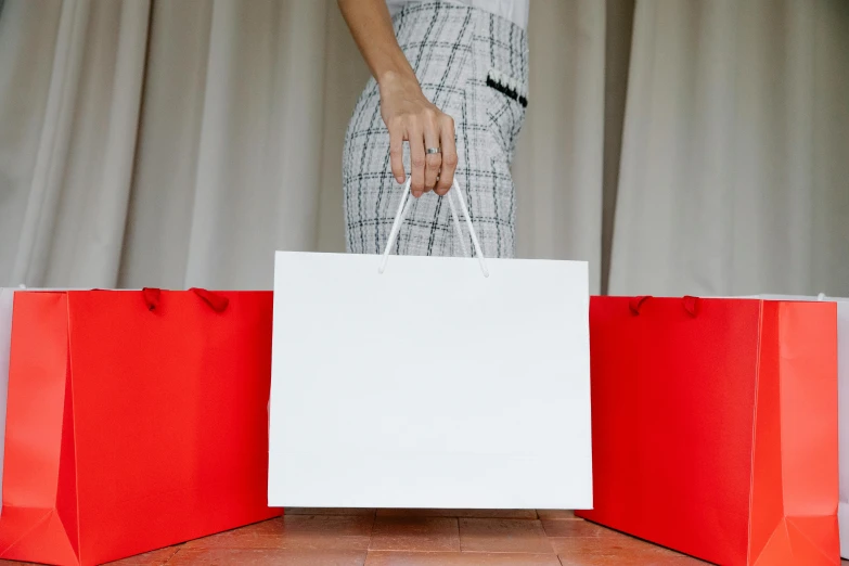 a woman holding two red and white shopping bags, pexels contest winner, product display, thumbnail, rectangle, opening shot