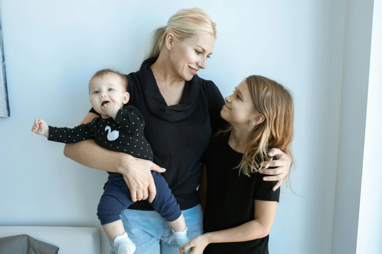 a woman holding a baby in her arms, pexels contest winner, minimalism, three women, blonde, 15081959 21121991 01012000 4k, manuka