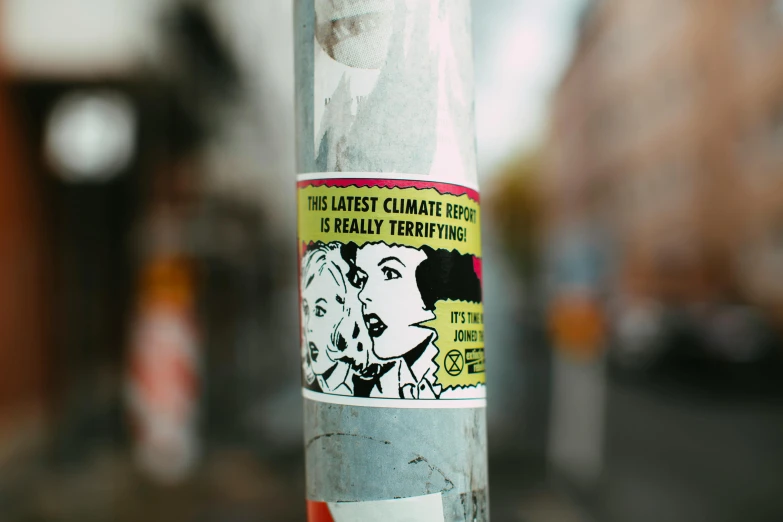 a close up of a sticker on a pole, a cartoon, by Joe Bowler, trending on pexels, lesbians, global warming, street printed poster, tape