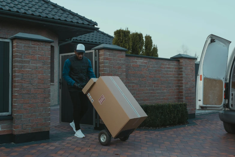 a man loading a box onto a moving truck, pexels contest winner, trending on r/streetwear, in front of the house, avatar image, color footage