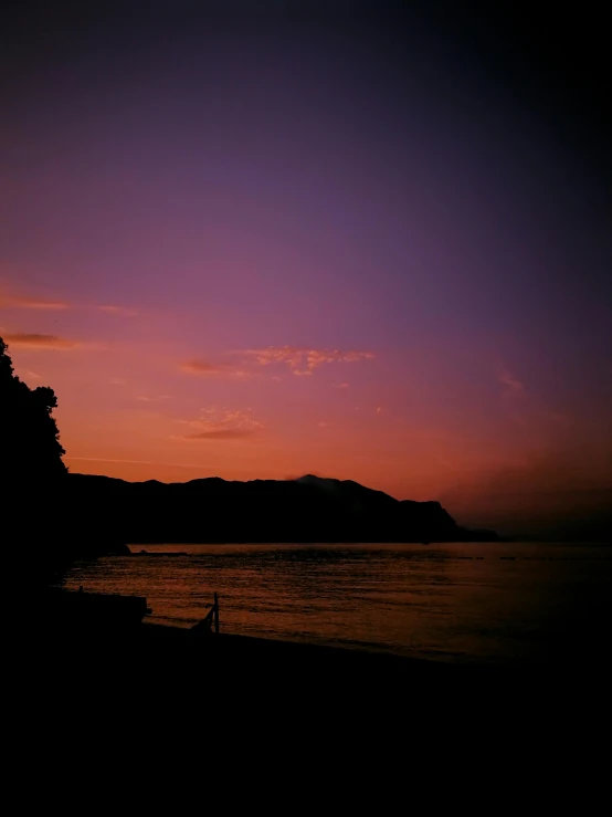 a couple of people standing on top of a beach, by Aguri Uchida, sumatraism, nightfall. quiet, second colours - purple, iphone picture