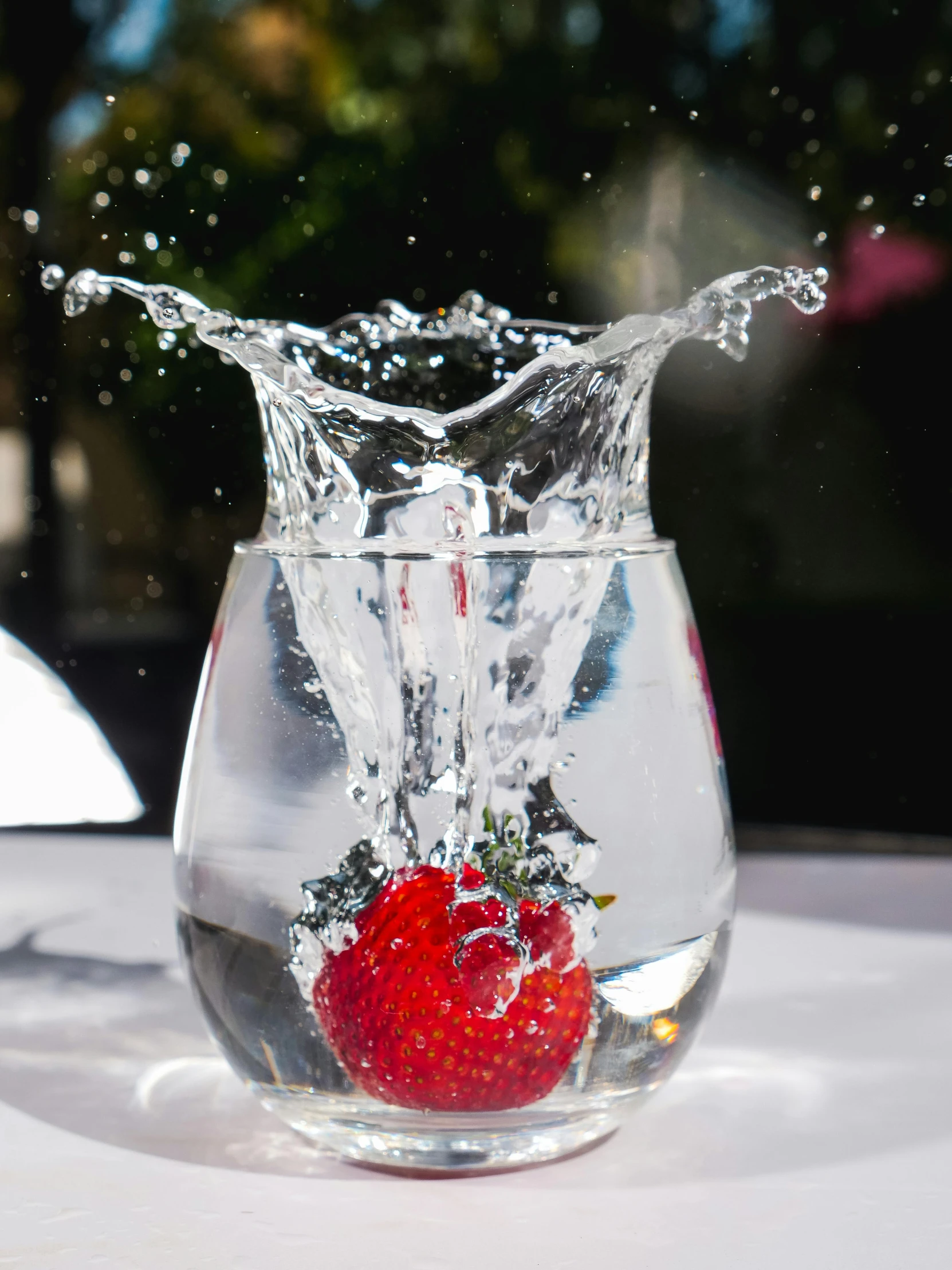 a strawberry splashing into a glass of water, unsplash, in a short round glass vase, berries inside structure, promo image, closeup - view