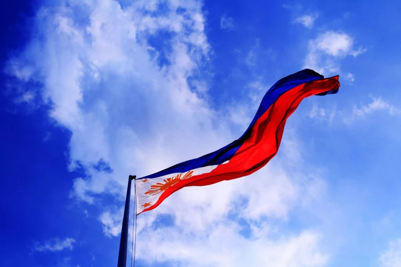 a red, white and blue flag flying in the sky, by Robbie Trevino, pexels contest winner, hurufiyya, 1970s philippines, sanctions in russia, 🚿🗝📝, red orange blue beige