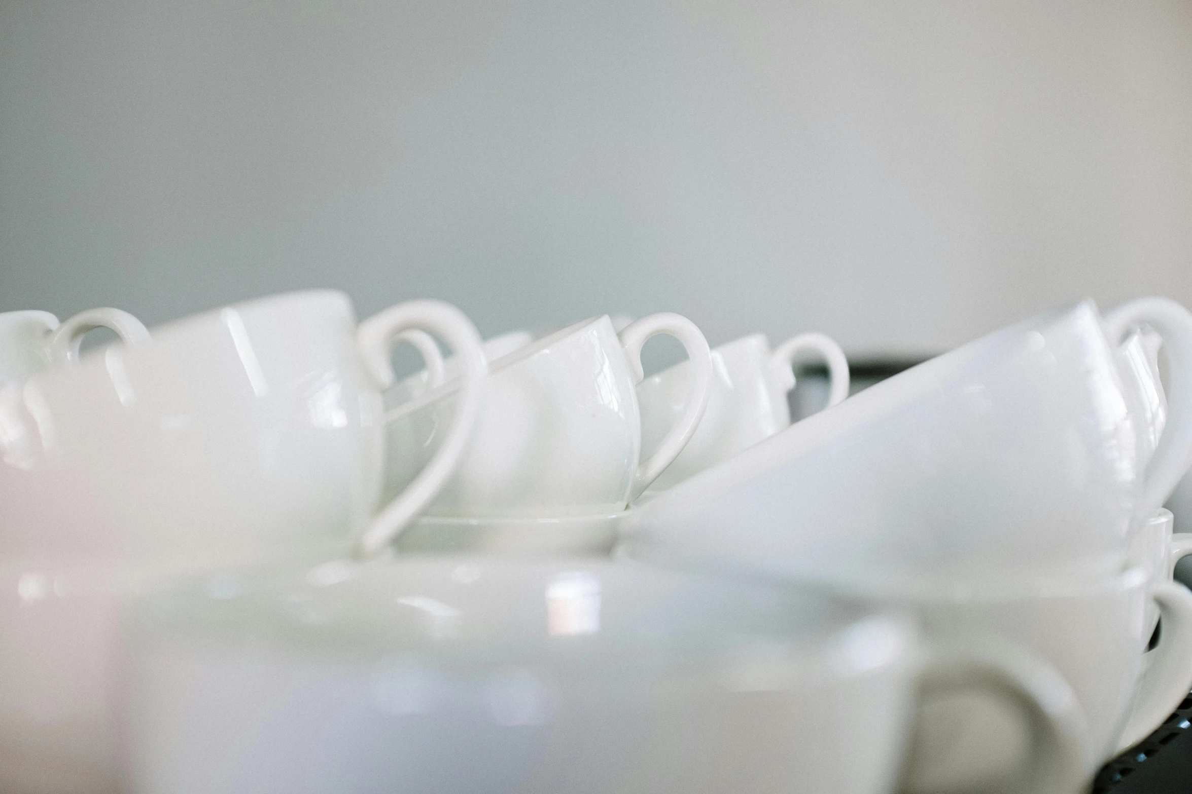 a bunch of coffee cups stacked on top of each other, a still life, unsplash, gleaming white, delicate soft hazy lighting, in a row, plates