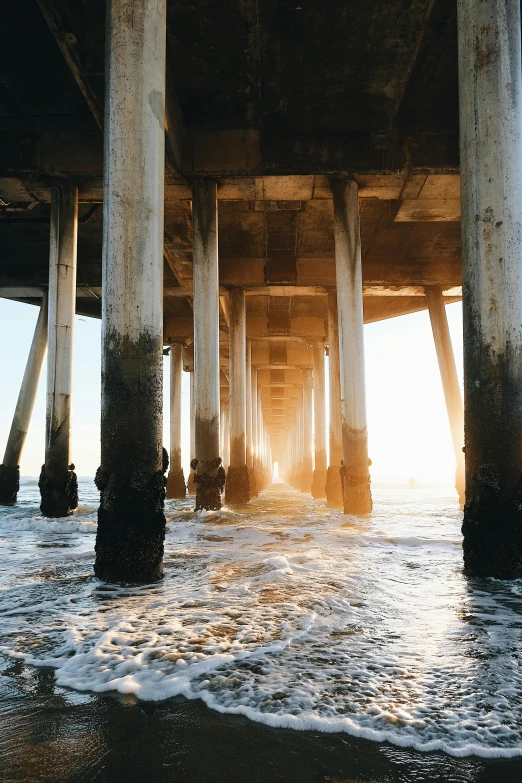 the sun shines through the pillars of a pier, unsplash contest winner, renaissance, los angeles ca, 4k photo”, wide angle”