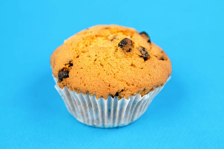 a muffin sitting on top of a blue surface, pexels, 15081959 21121991 01012000 4k, high quality photo, edible crypto, square